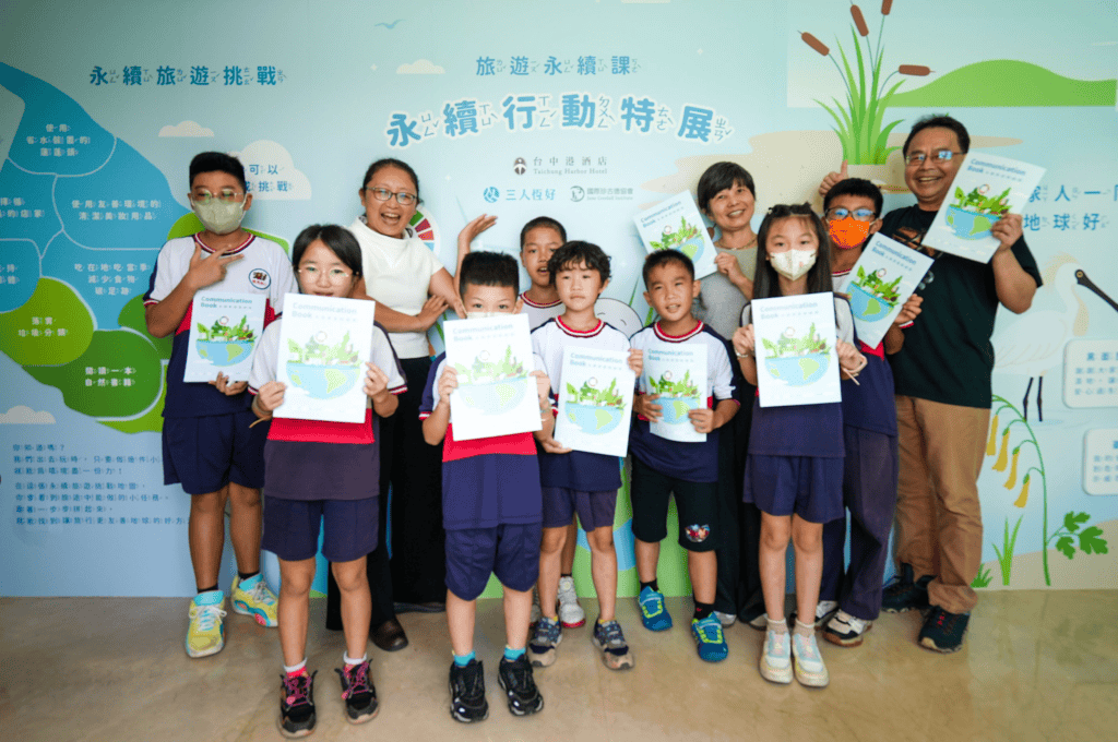 永續旅遊挑戰：學生們拿著永續家庭聯絡簿